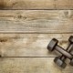 28217980-a-pair-of-vintage-iron-rusty-dumbbells-on-a-weathered-wood-background-with-a-copy-space